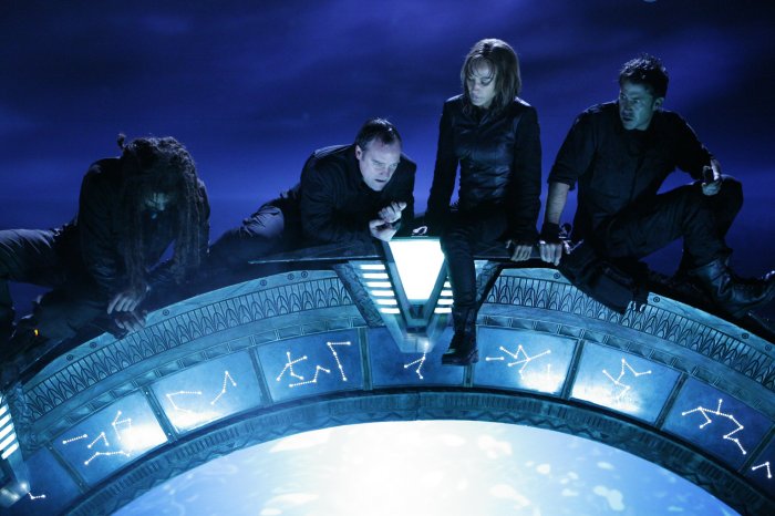 Sheppard's team scrables to the top of the Stargate.
