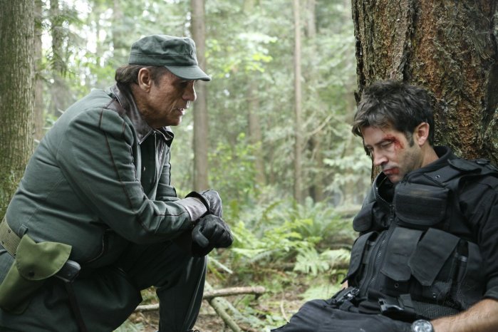 Kolya (Robert Davi) subjects Sheppard (Joe Flanigan) to beating and torture.
