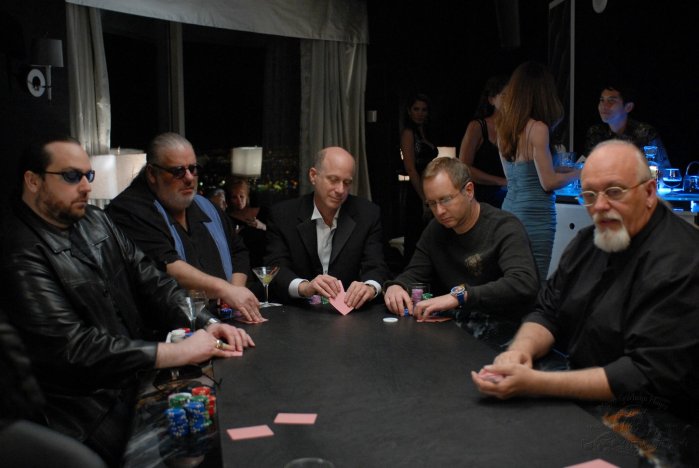 The big poker match includes some famous faces, including (from left to right) poker pro Todd Brunson, Atlantis composer Joel Goldsmith, and MGM exec Charlie Cohen (center).

